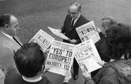 People reading newspapers with headlines about European unity.