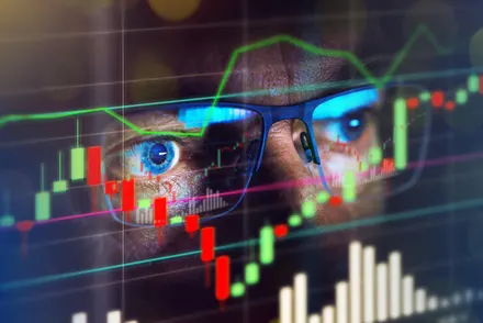 Close-up of eyes reflecting financial charts and data on screen.